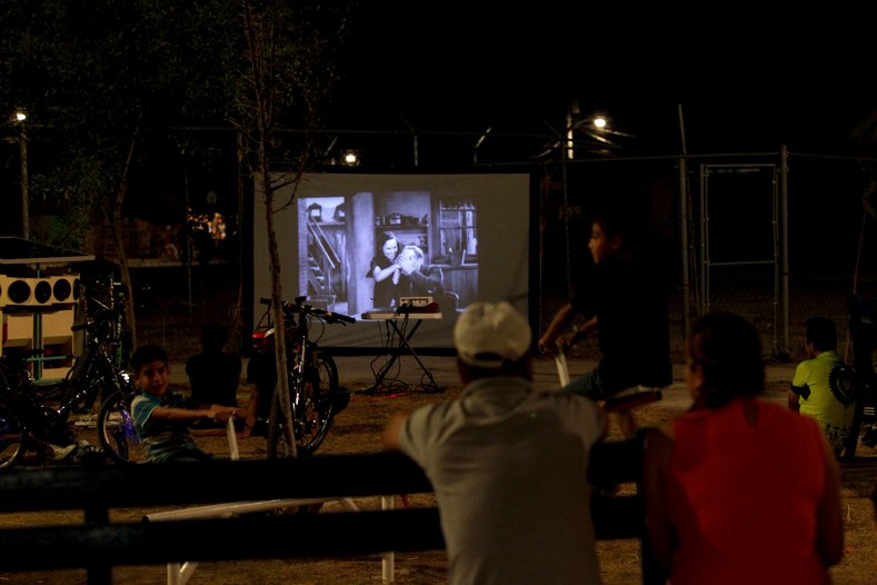 Residents watch a film projected by the Cinecleta, Moviebike, at a park in Saltillo, Mexico, Sept. 6, 2015.
