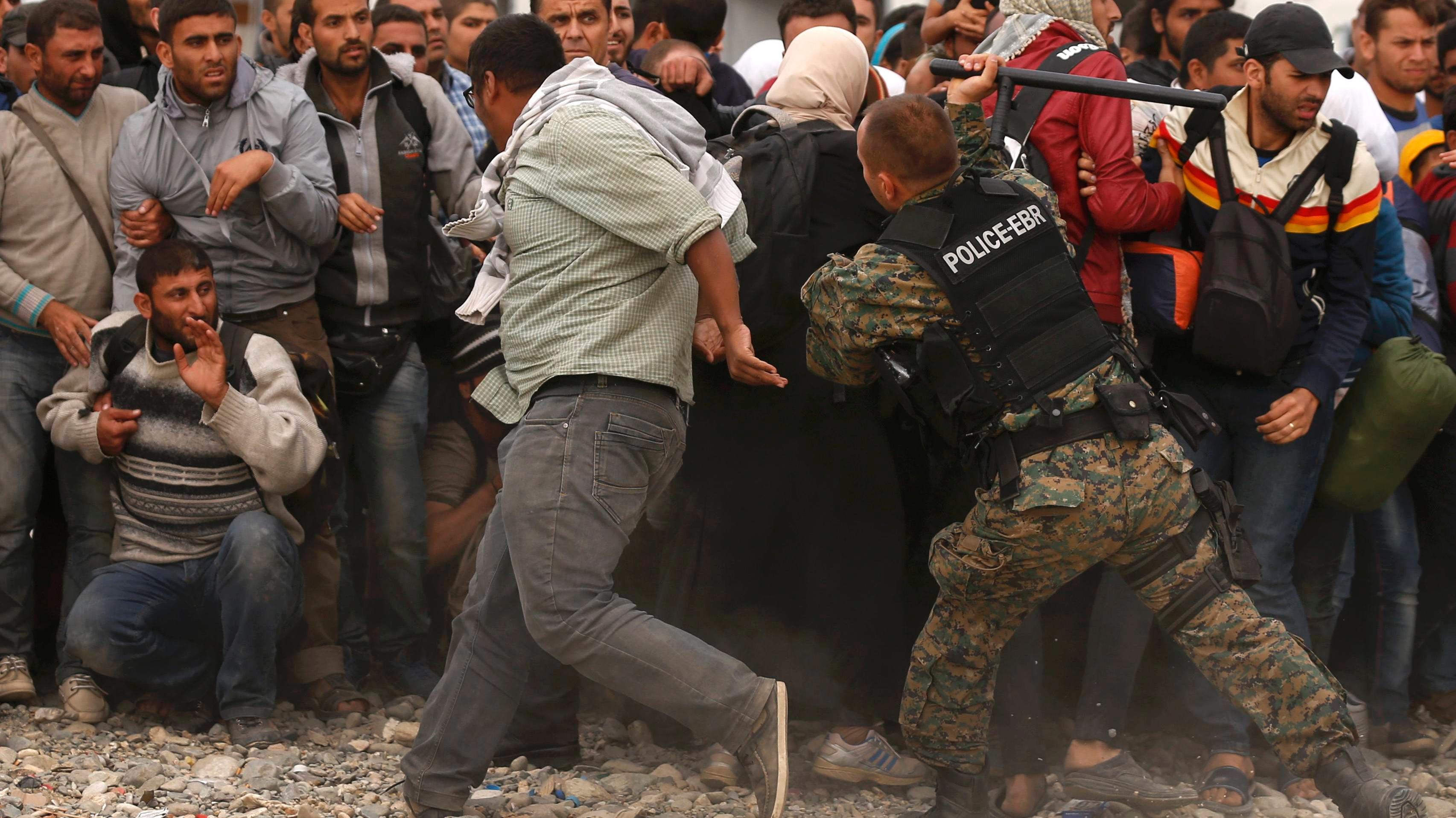 A Macedonian police officer hits a migrant in a camp near Gevgelija. While Venezuela has long welcomed refugees, Europe has dragged its feet on resolving its own refugee crisis.