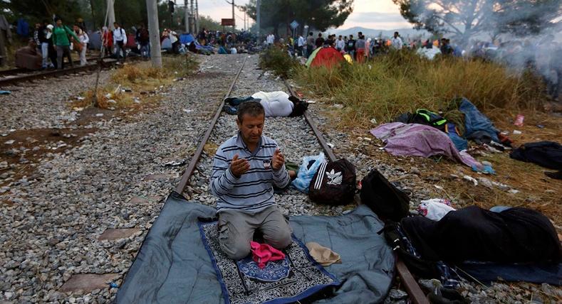 A Syrian refugee prays on a rail track at the Greek-Macedonian border, near the village of Idomeni, August 22, 2015