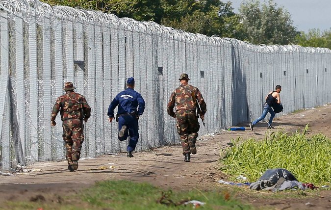 Officers chase a migrant who crossed into Hungary on Saturday