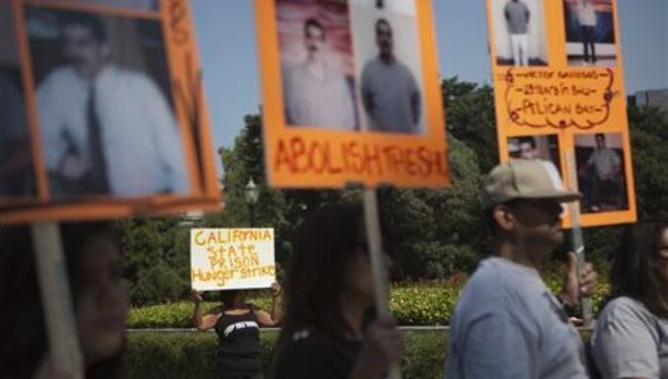 Elaine Gurule (in the background) holds up a sign during a protest against indefinite solitary confinement in California prisons, at the State Capitol in Sacramento, California July 30, 2013. Her two sons are currently in solitary confinement.