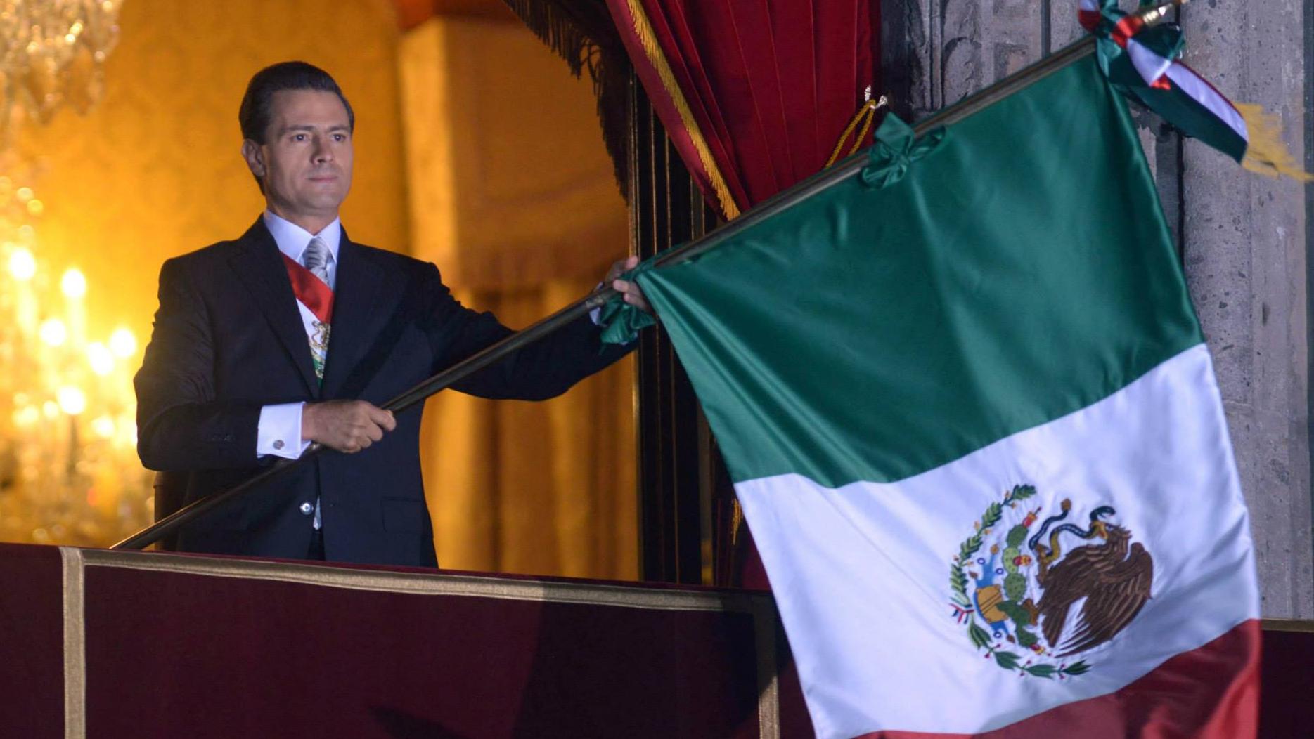 Mexican President Enrique Peña Nieto waves the National flag during the independence ceremony in Mexico City, 15 September 2015.