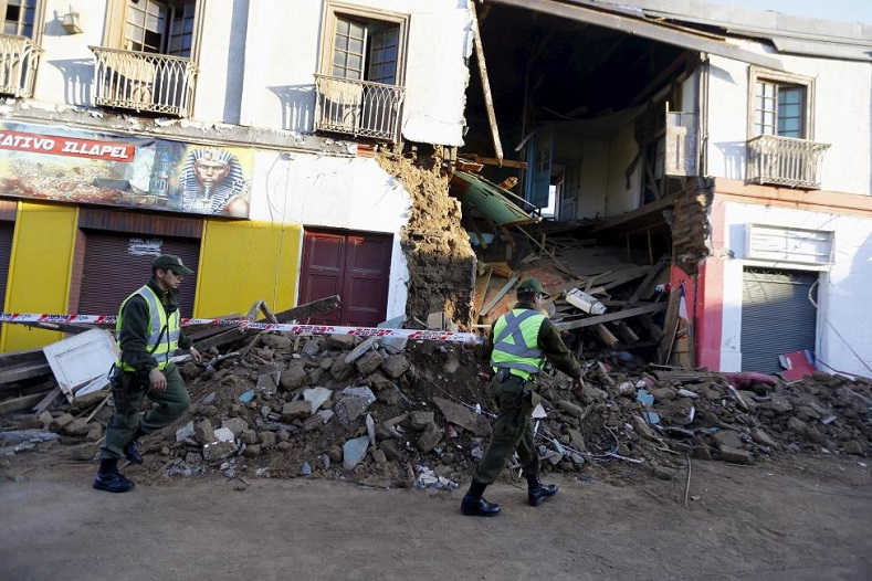 Police officers put barricade tape in front of a damaged building after an earthquake hit areas of central Chile, in Illapel town, north of Santiago, Chile, September 17, 2015.