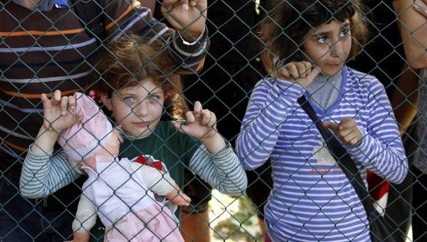 Two refugee girls wait to cross the border between Serbia and Croatia in Tovarnik
