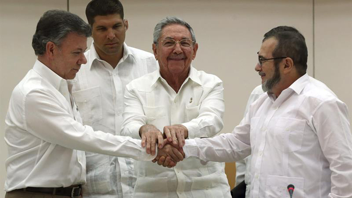Colombian President Juan Manuel Santos (L) Cuban President Raul Castro (C) and FARC Commander Timoleon Jimenez (R) shake hands after signing an agreement regarding transitional justice in Havana, Cuba, Sept. 23, 2015.