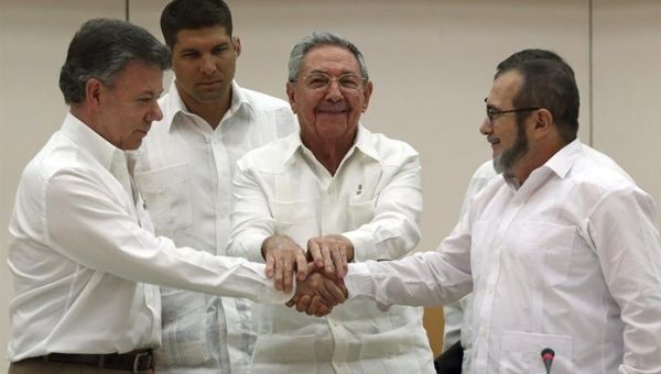 Colombian President Juan Manuel Santos (L) Cuban President Raul Castro (C) and FARC Commander Timoleon Jimenez (R) shake hands after signing an agreement regarding transitional justice in Havana, Cuba, Sept. 23, 2015.