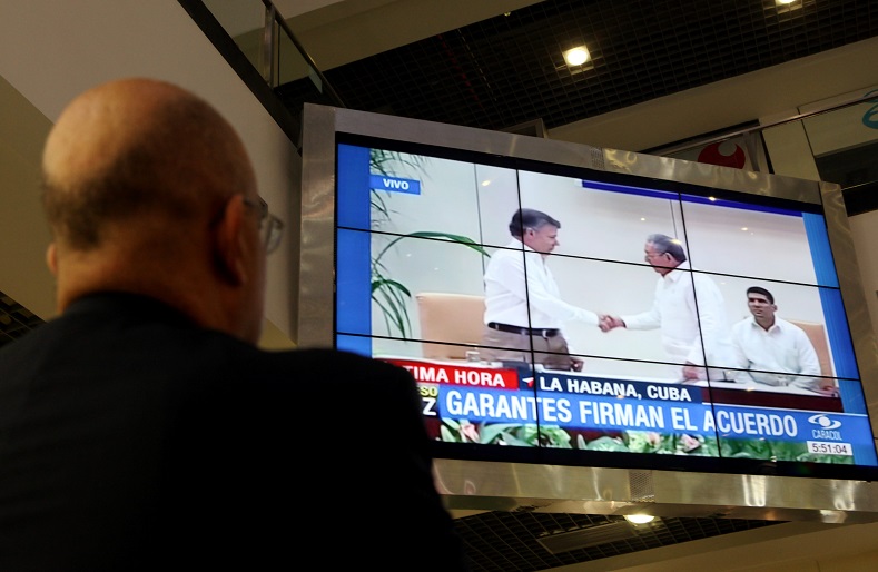 A man waches the televised transmission of the peace negotiations in Havana