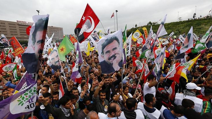 Supporters of the Pro-Kurdish Peoples' Democratic Party (HDP) wave flags with a picture of the jailed Kurdish leader Abdullah Ocalan and flags with a picture of Turkey's founder Ataturk during an election rally.