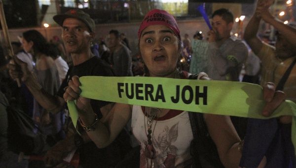 A demonstrator gestures as she holds a headband reading 'Juan Orlando Hernandez out' during a march to demand the resignation of Honduras' President Hernandez in Tegucigalpa, September 11, 2015. The protesters are calling for the resignation of Hernandez over a $200-million corruption scandal at the Honduran Institute of Social Security.