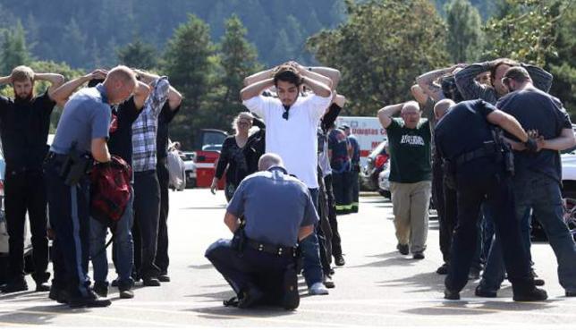 Police officers inspect bags as students and staff are evacuated from campus following a shooting incident at Umpqua Community College in Roseburg, Oregon October 1, 2015.