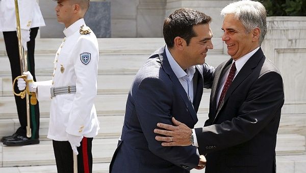 Greek Prime Minister Alexis Tsipras (L) greets Austrian Chancellor Werner Fraymann. 