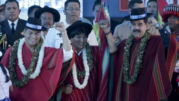 Bolivian President Evo Morales (C) gestures with the presidents of Ecuador and Venezuela during a closing ceremony of the climate change conference in Bolivia, Oct. 12, 2015. 