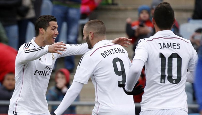 Cristiano Ronaldo celebrates a goal with Karim Benzema. Colombian star James Rodriguez approaches the duo to share the joy.