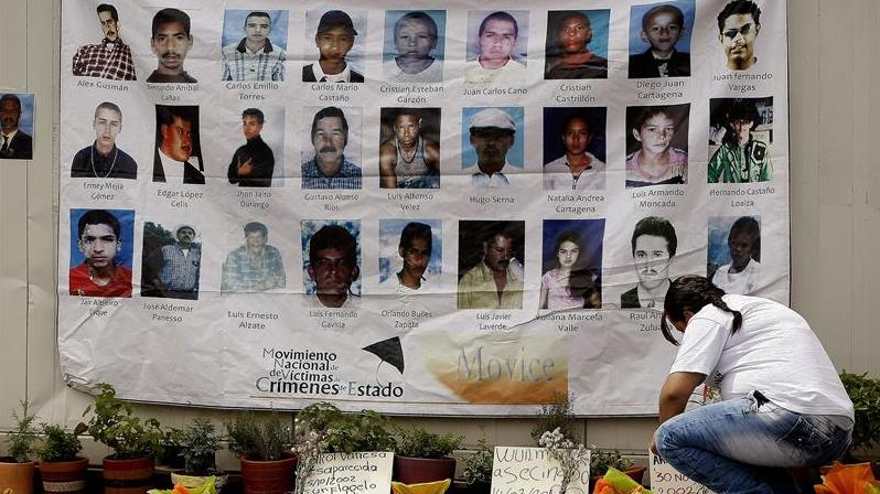 A woman commemorates a group of victims killed or 
