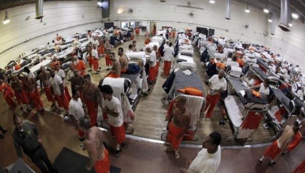 Inmates walk around a gymnasium where they are housed due to overcrowding at the California Institution for Men state prison in Chino, California, June 3, 2011.