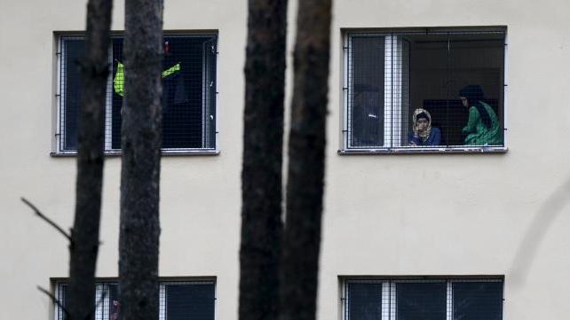 Refugees stare out of the window of a Czech migrant detention center.
