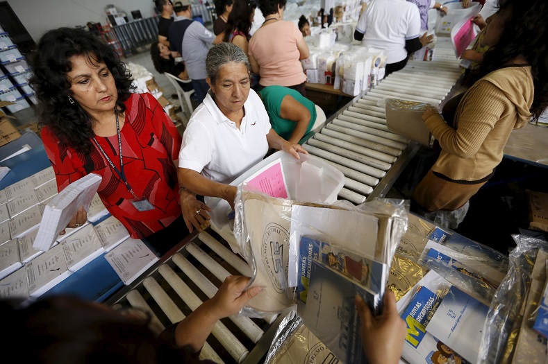 Employees pack electoral material and ballots in boxes, which will be distributed throughout the country, at a warehouse in Guatemala City October 21, 2015.