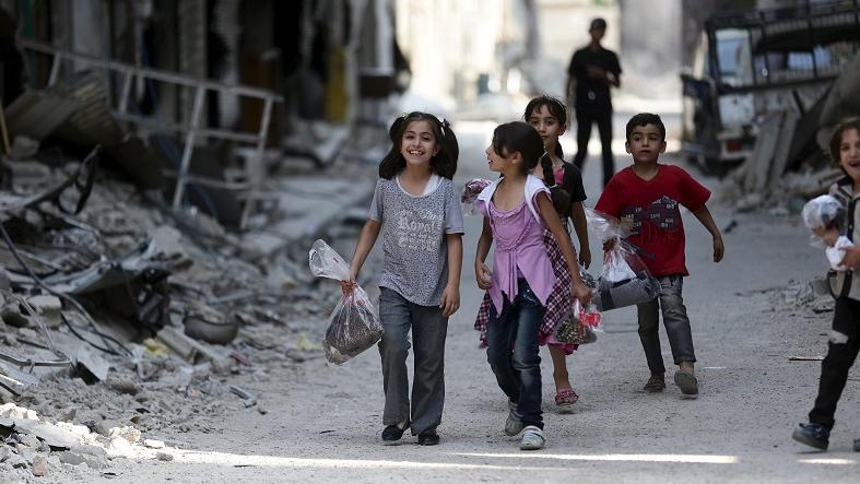 Children carry bags with new clothes ahead of the Eid al-Fitr holiday in Jobar, a suburb of Damascus, Syria.
