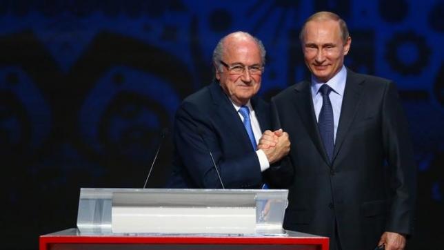 FIFA's President Sepp Blatter shakes hands with Russia's President Vladimir Putin (R) during the preliminary draw for the 2018 FIFA World Cup.