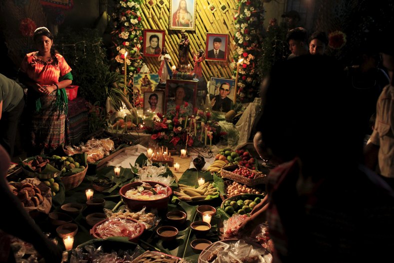 A girl stands at a family altar during the celebration of 