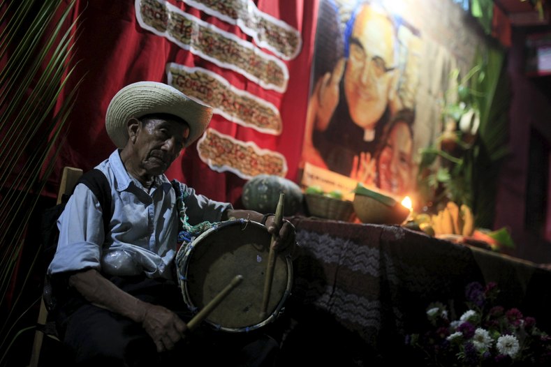 A man plays the drum at a family altar during the celebration of 