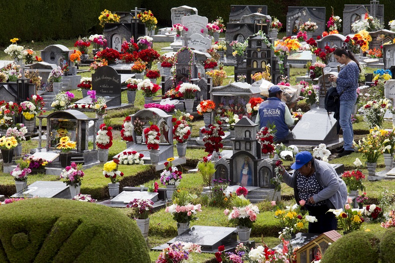 People clean graves at a cemetery known for its topiary art, during the observance of the Day of the Dead, in Tulcan, Ecuador.
