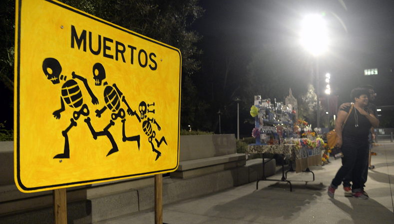 A 'Dia de Los Muertos' (Day of the dead) altar showing a sign of 'dead' skeleton migrant characters running across a high-way called 'Metros Crossing' by Lalo Alcatraz is displayed at Grand Park, in downtown Los Angeles, California.