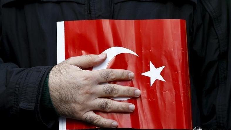 A supporter of Gulen movement holds Turkey's national flag during a protest outside the Kanalturk and Bugun TV building in Istanbul, Turkey, Oct. 28, 2015.