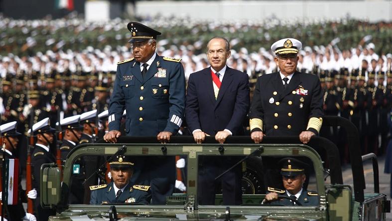 Then Mexican President Felipe Calderon (C) of the National Action Party reviews troops during a military parade in Mexico City, Sept. 16, 2012.