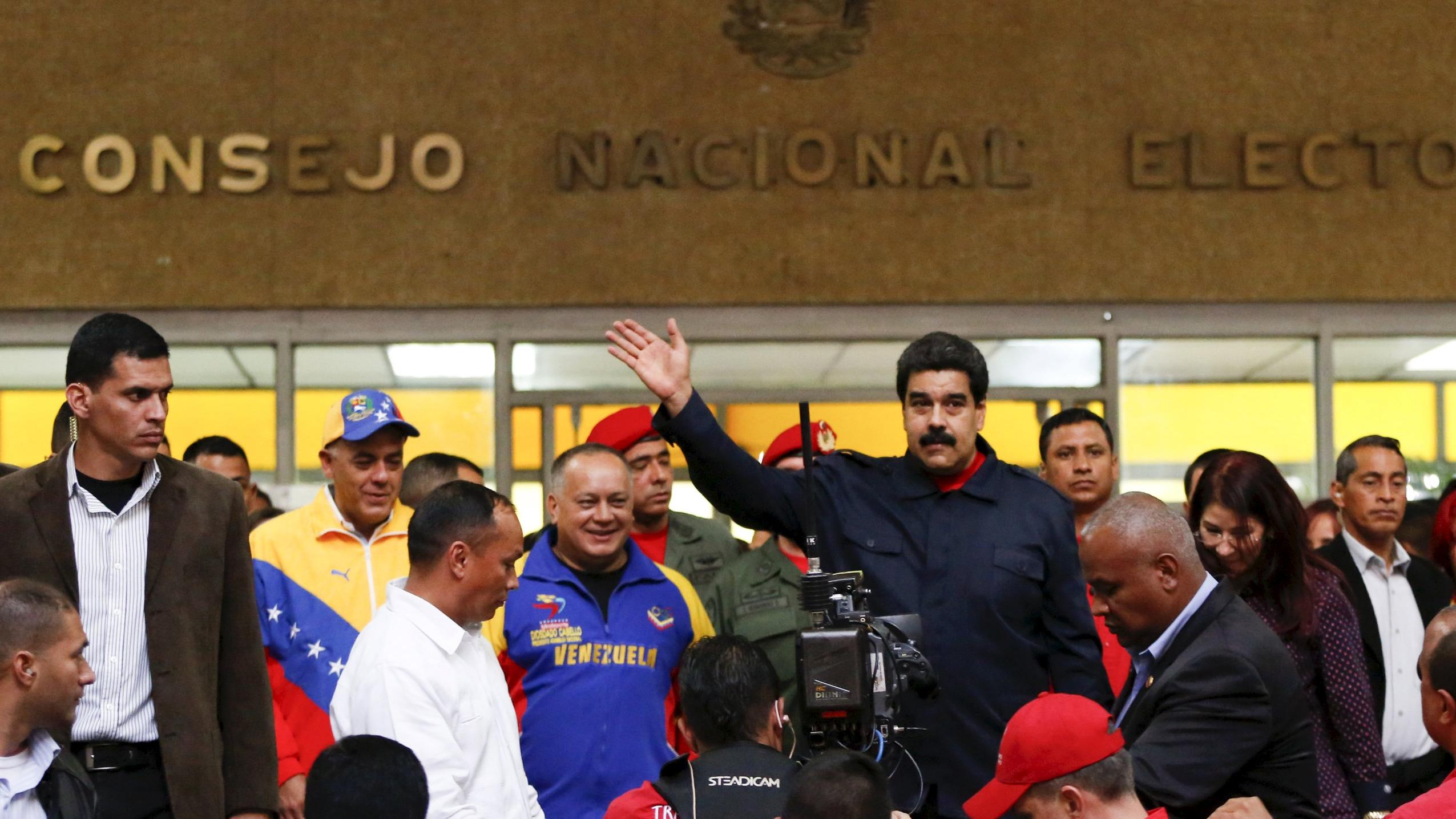 Venezuela's President Nicolas Maduro (C) waves as he walks out of the National Electoral Council (CNE) headquarters in Caracas October 26, 2015.