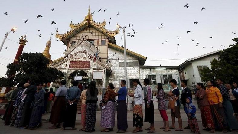 People line up outside a Buddhist prayer hall to vote during the general election in Mandalay, Myanmar, Nov. 8, 2015.