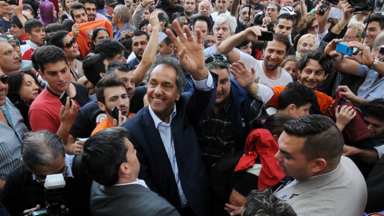 Presidential candidate Daniel Scioli waves amid supporters.