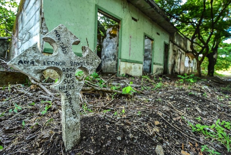 A commemorative cross with the name of a person who disappeared in the 1985 disaster is seen near the ruins of a house in the town of Armero, Colombia, Nov. 5, 2015