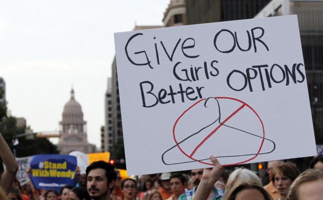 Protesters carry signs during an abortion rights march that originated at the State Capitol in Austin, Texas, in this file photo taken July 8, 2013.