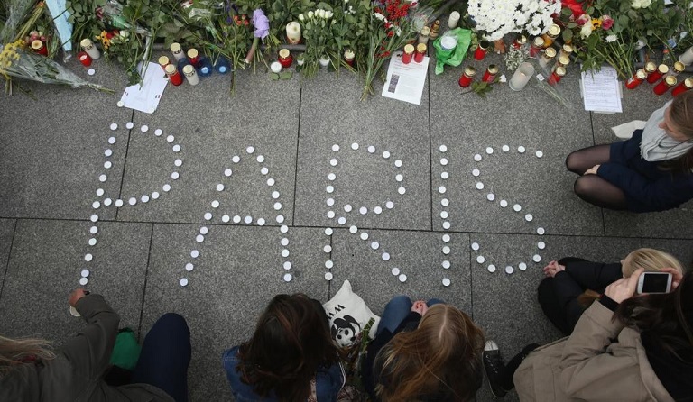 People finish arranging candles into the word 'Paris' next to flowers and messages left at the gate of the French Embassy following the recent terror attacks in Paris on Nov. 14, 2015 in Berlin, Germany.