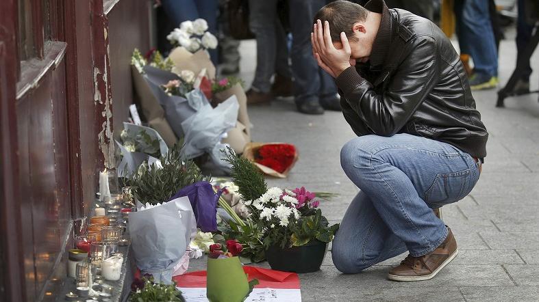 A man pays his respect outside the Le Carillon restaurant the morning after a series of deadly attacks in Paris Nov. 14, 2015.