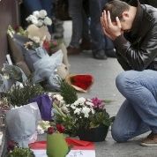A man pays his respect outside the Le Carillon restaurant the morning after a series of deadly attacks in Paris Nov. 14, 2015.