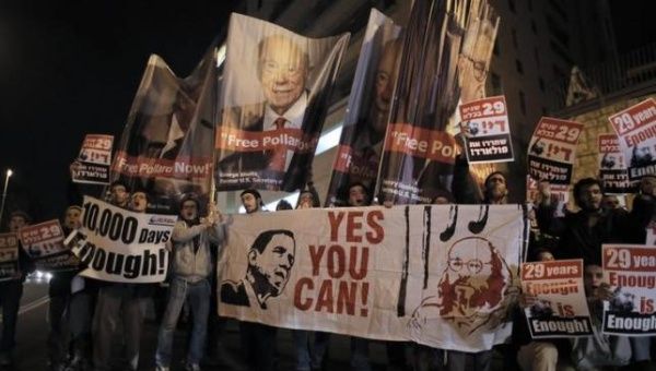 Israelis hold placards during a protest calling for the release of Jonathan Pollard from a U.S. prison, in Jerusalem, Jan. 2, 2014.