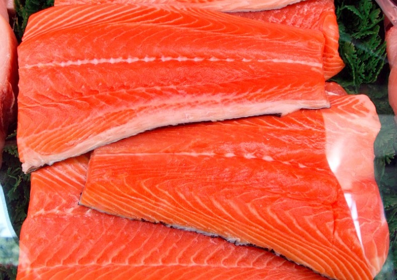 Slabs of salmon are displayed at a market.
