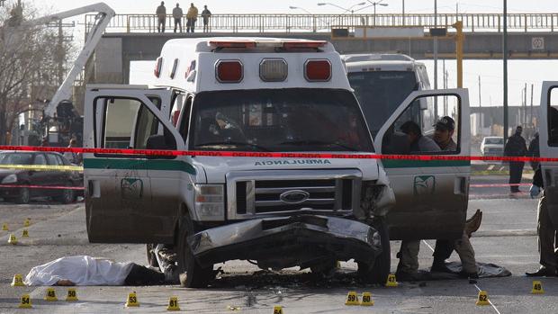 Forensic workers are seen at a crime scene where an ambulance had been attacked earlier by gunmen in Ciudad Juarez, Mexico.