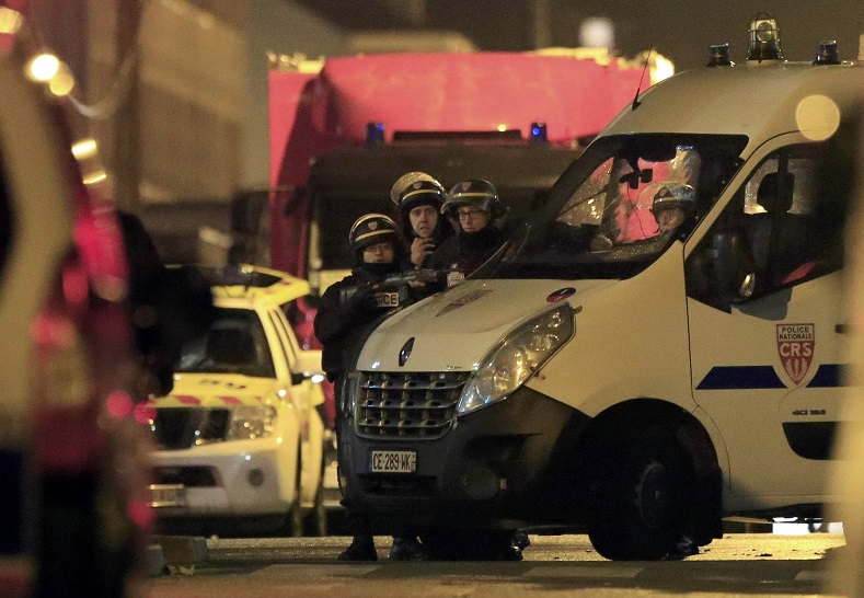 Police take up position near the scene of a shootout in Roubaix, northern France, November 24, 2015.
