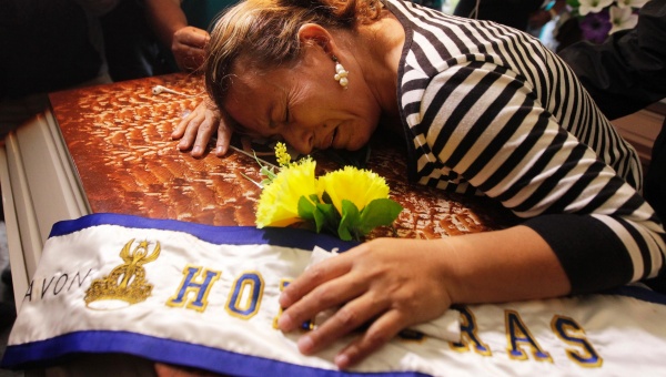 Teresa Munoz mourns over the coffin of her daughter Maria Jose Alvarado during a wake for Maria Jose and her sister Sofia in Honduras Nov. 20, 2014.