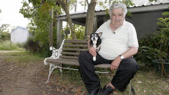 Uruguay's Jose Mujica pose for a picture with his dog Manuela after an interview with Reuters in his farm in the outskirts of Montevideo, Feb. 25, 2015.