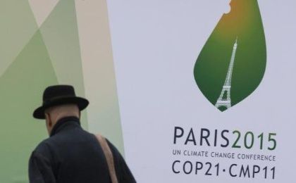 A passerby walks in front of posters for the forthcoming COP 21 World Climate Summit in Paris, France, Nov. 2, 2015.
