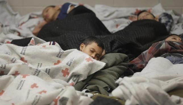 Detainees sleep in a holding cell at a U.S. Customs and Border Protection processing facility, in Brownsville, Texas Jun.18, 2014.