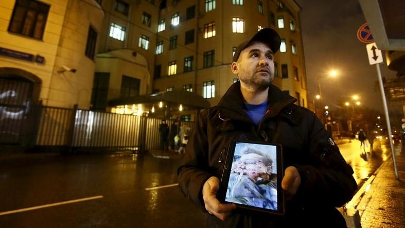 An activist holds a tablet with a picture of the Russian pilot of a war plane shot down by Turkey, in front of the Turkish embassy in Moscow, Russia, Nov. 24, 2015.