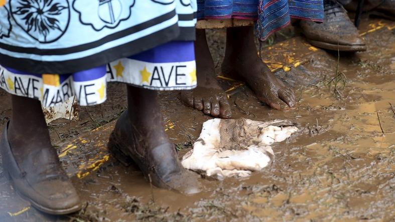 Faithful stand in the mud as they attend a mass by Pope Francis in Kenya's capital Nairobi.