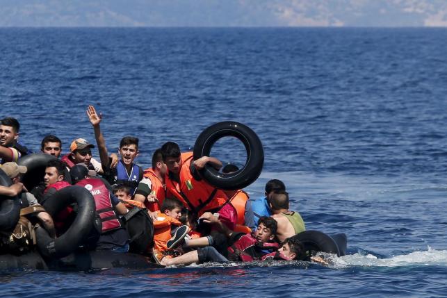 Syrian and Afghan refugees fall into the sea after their dinghy deflated some 100m away before reaching the Greek island of Lesbos, Sep.13, 2015.