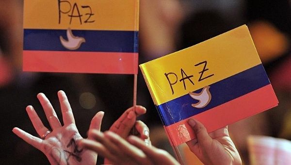 Colombians hold up mock flags supporting the peace process.