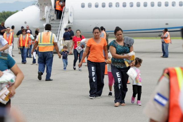 Women and their children walk on the tarmac after being deported from the U.S., at the Ramon Villeda international airport in San Pedro Sula, June 2014.